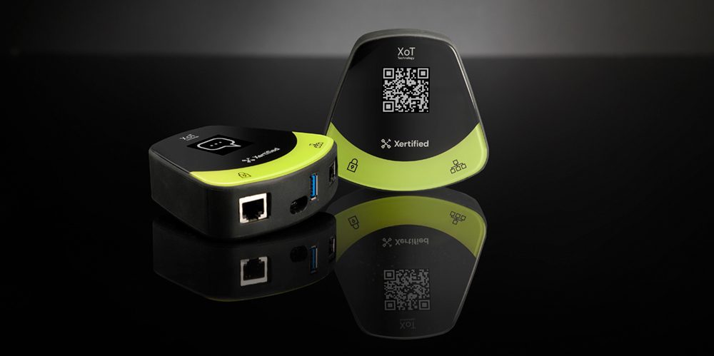Två lås av modellen XoT-S1, svarta med grön kant. Det ena visar nätverksuttag och USB-port.